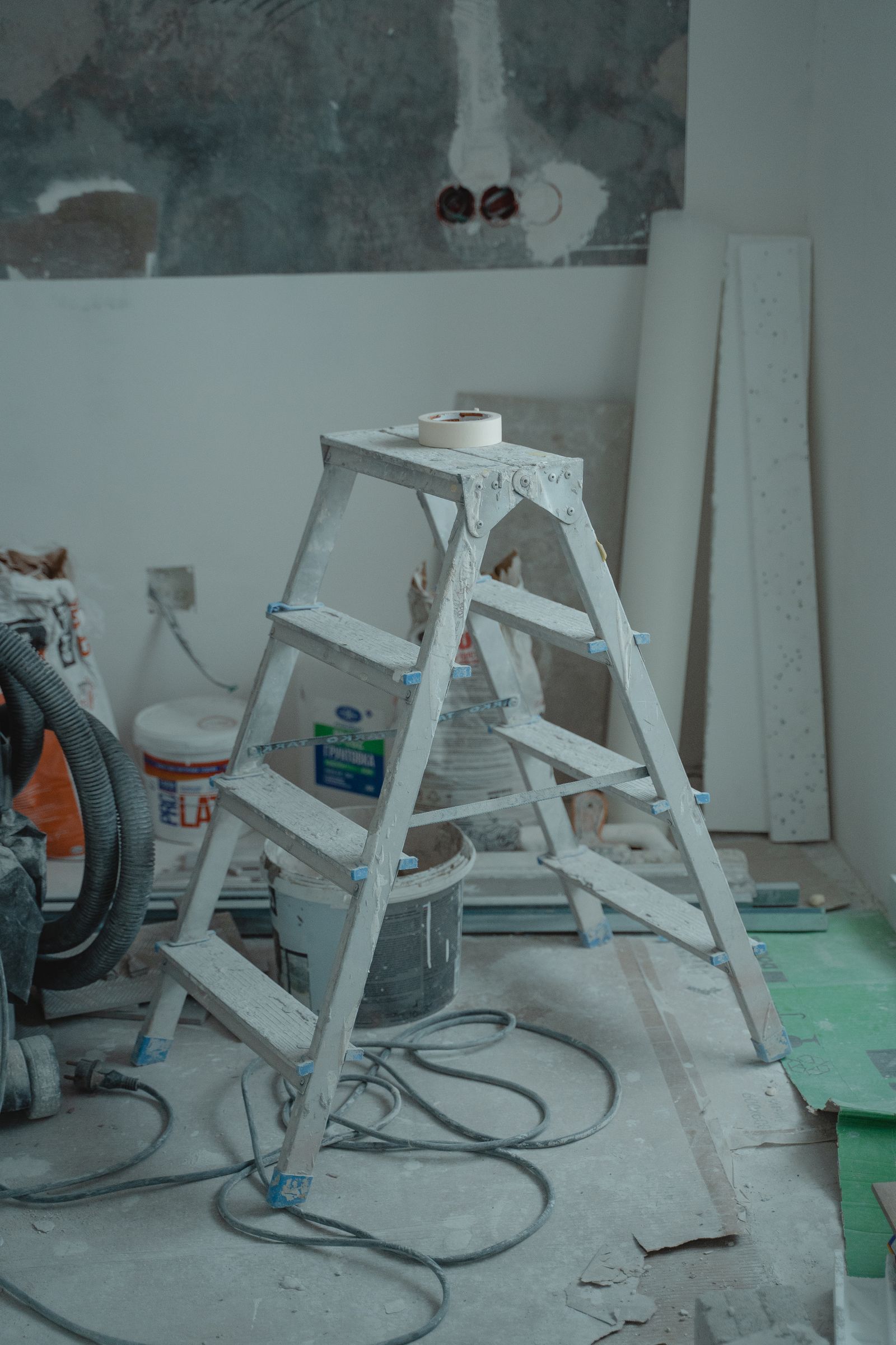 Step ladder and painting equipment staged in a room under renovation