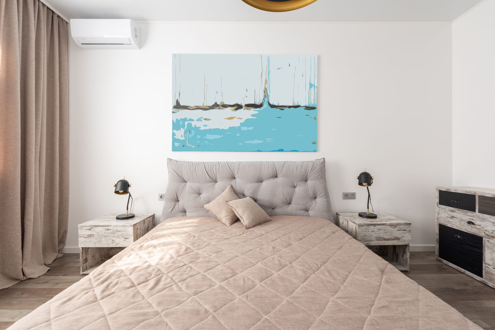 A finished bedroom with painted walls, a bed, curtains, flooring, and two bedside lamps
